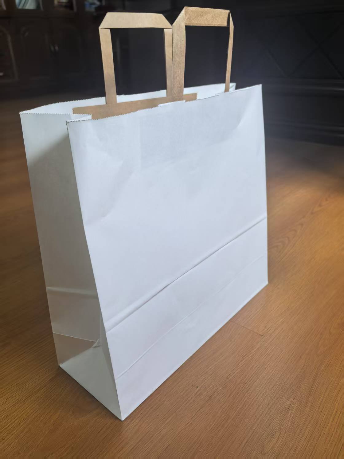 Side view of square bottom paper bag with flat paper handle made by full automatic paper bag making machine with handle